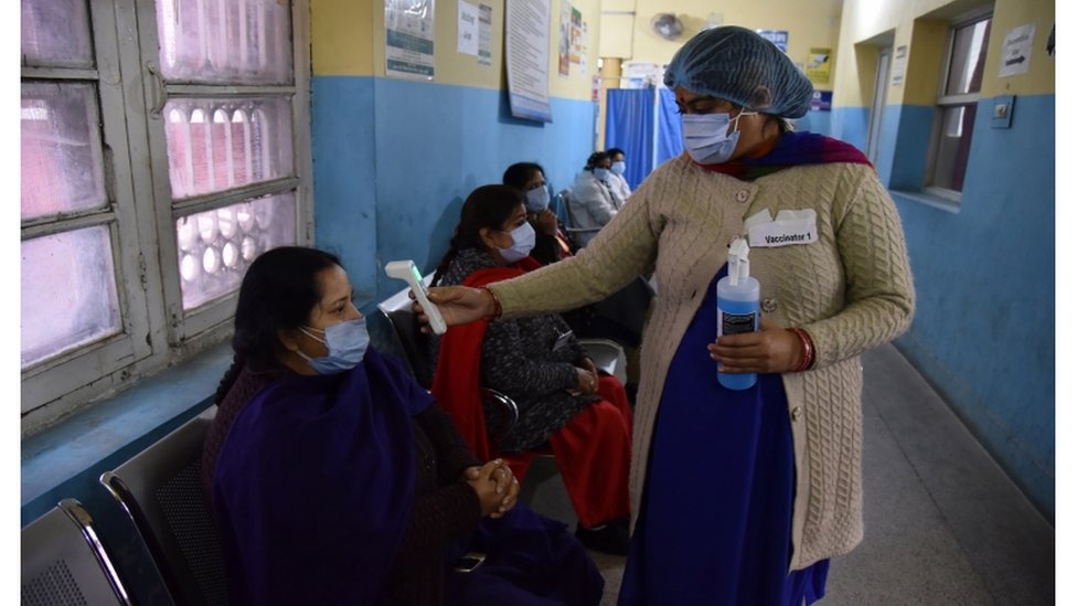 Enfermeira indiana mede a temperatura de paciente