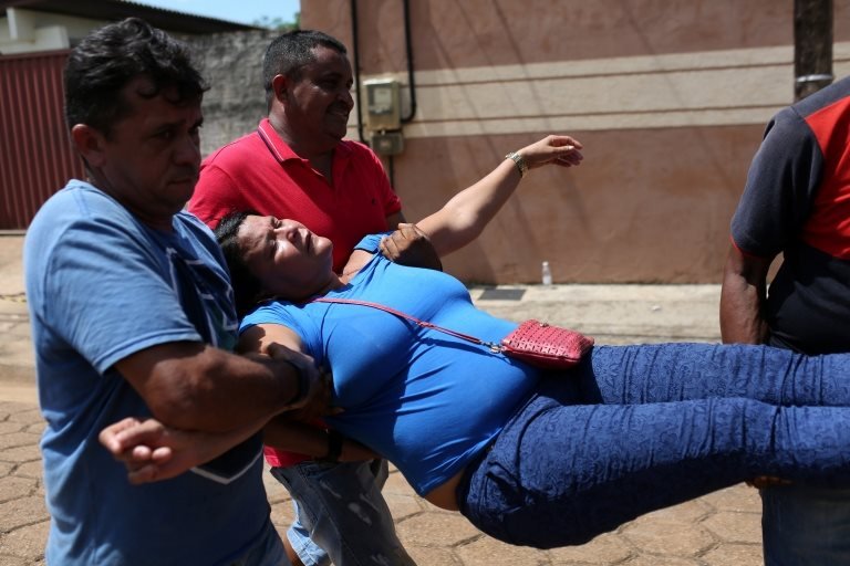 A relative of a prisoner is carried away after she fainted in front of the Medical Legal Institute of Altamira, Brazil, July 30, 2019
