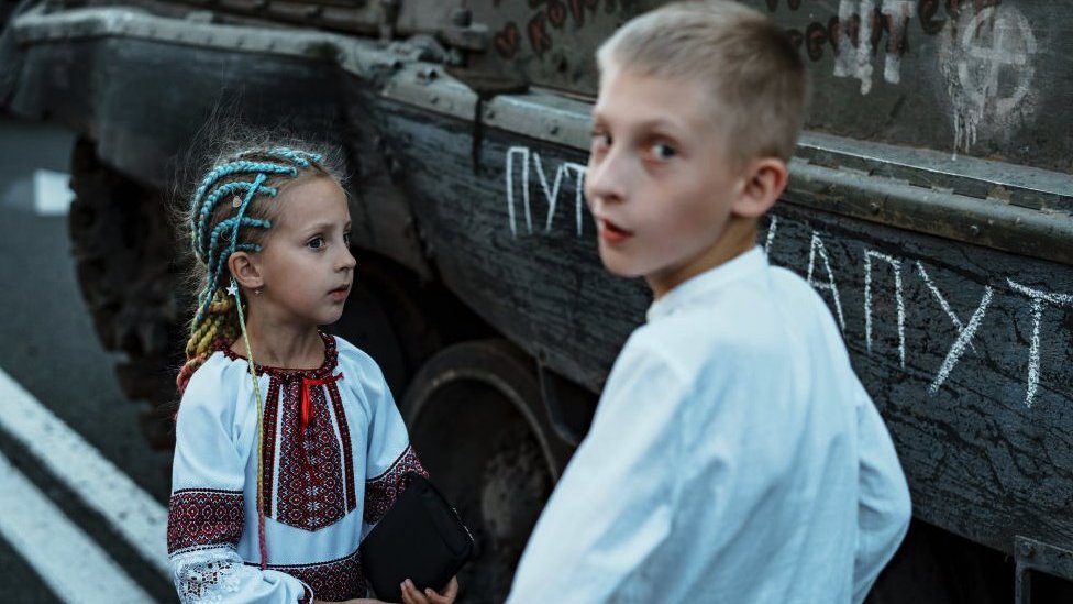 Ukrajinska deca se igraju blizu izložene zaplenjene ruske vojne opreme