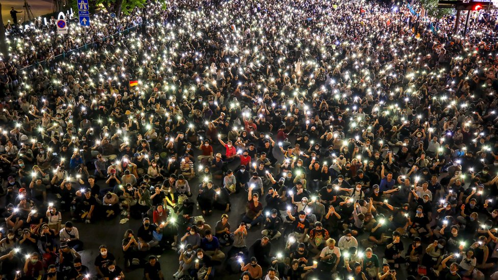 Протестующие, выступающие за демократию, держат свои мобильные телефоны во время митинга против введения чрезвычайного положения в торговом районе Ратчапрасонг в Бангкоке, Таиланд, 15 октября 2020 года.