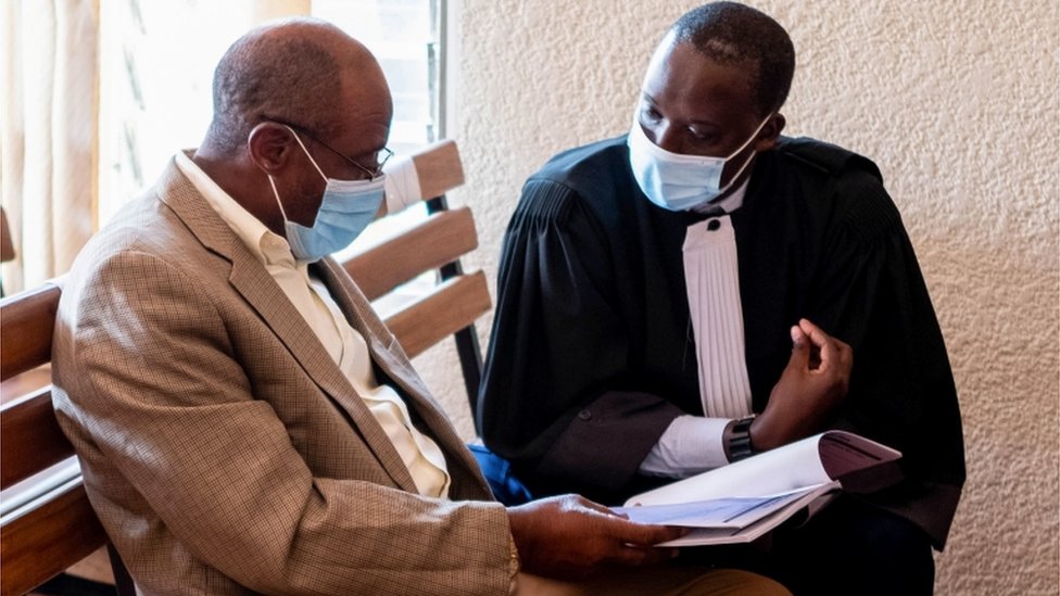 Пол Русесабагина, изображенный как герой голливудского фильма о геноциде в Руанде в 1994 году, разговаривает со своим адвокатом в суде первой инстанции Кициикури в Кигали.