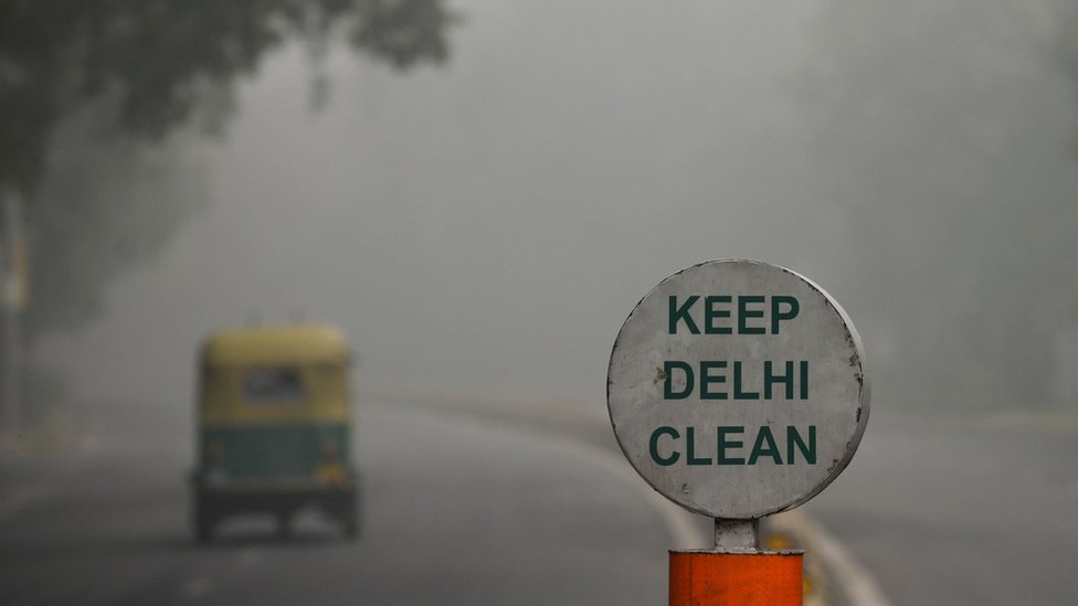 Вывеска с надписью «Держите Дели в чистоте» на фоне густого смога