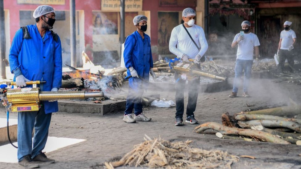 Добровольцы распыляют дезинфицирующее средство на месте кремации индуистов Шивпури во время общенациональной блокировки, введенной правительством в качестве превентивной меры против коронавируса COVID-19, в Амритсаре 11 апреля 2020 г.