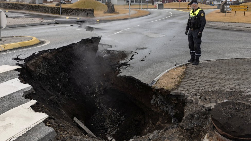 A policeman stands by the crack in a road in the town of Grindavik, south-western Iceland. Photo: 15 November 2023