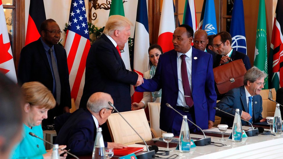 Президент США Дональд Трамп и президент Нигера Махамаду Иссуфу (C-R) обмениваются рукопожатием