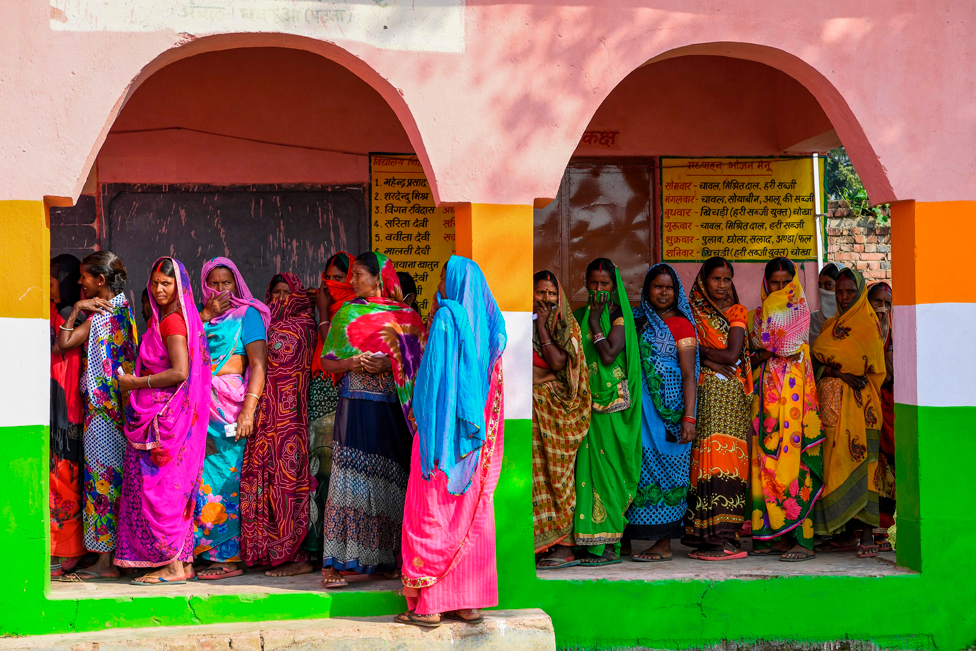 Voters queue up to cast their ballots for Bihar state assembly elections at a polling station in Masaurhi on 28 October 2020