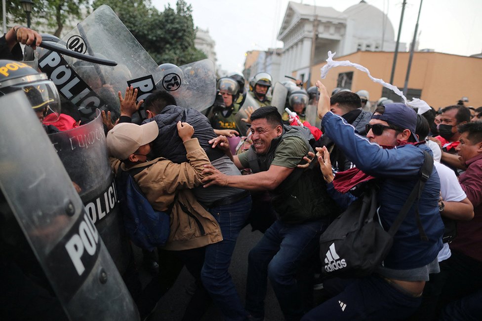 Demonstrators clash with riot police in Lima during a protest demanding presidential elections and the closure of Congress after the removal of Peruvian leader Pedro Castillo from office, 8 December 2022