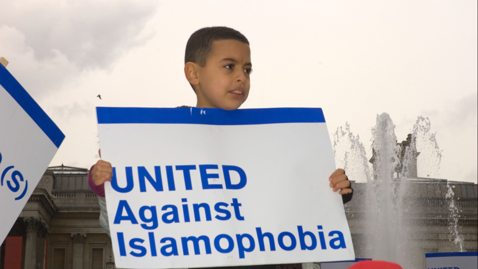 Мальчик держит плакат с надписью «Вместе против исламофобии»