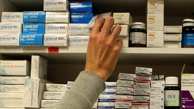 Pharmacist reaching for drugs