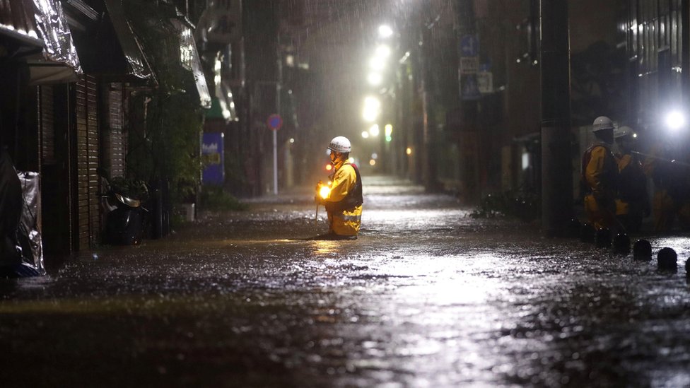 Пожарные патрулируют затопленную дорогу из-за проливных дождей, вызванных тайфуном Хагибис в Токио, Япония, 12 октября 2019 г.
