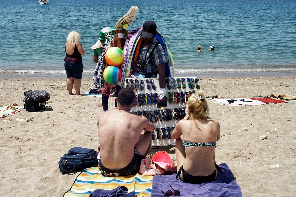 رجل يشتري نظارة شمسية على شاطئ يوناني