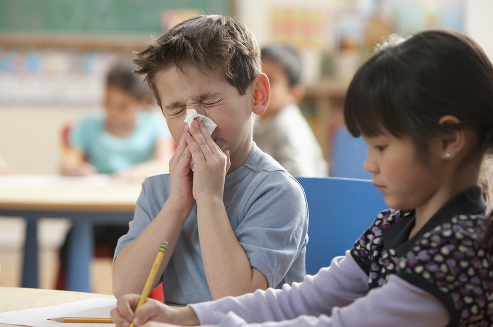 Un niño se sopla la nariz en clase