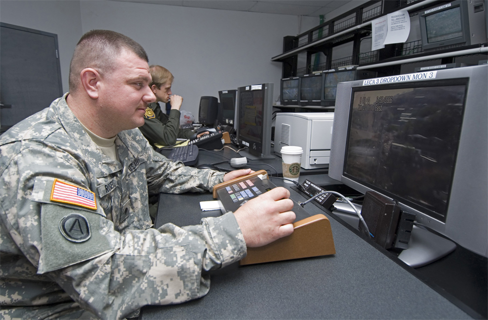 Soldado de la Guardia Nacional frente a monitores de vigilancia.
