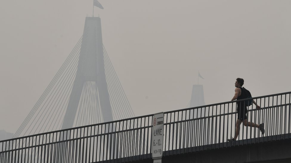 Мужчина бежит по мосту во вторник в Сиднее в дымной дымке