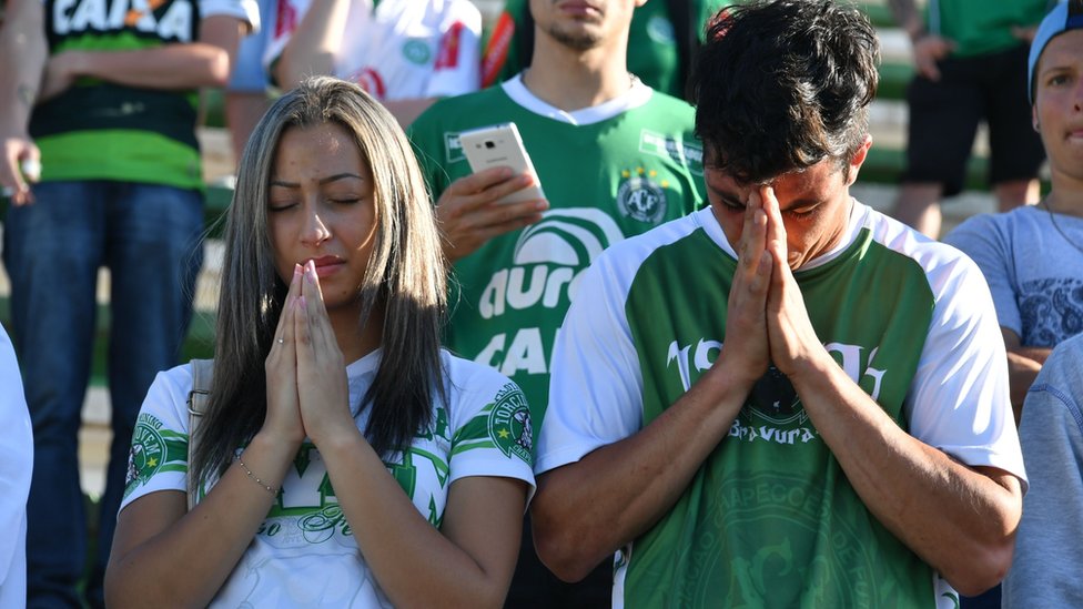 Люди отдают дань уважения игрокам бразильской команды Chapecoense Real, погибшим в авиакатастрофе в горах Колумбии на клубном стадионе Arena Conda в Чапеко