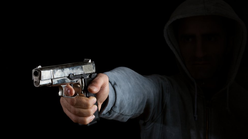 Hombre apuntando con un arma