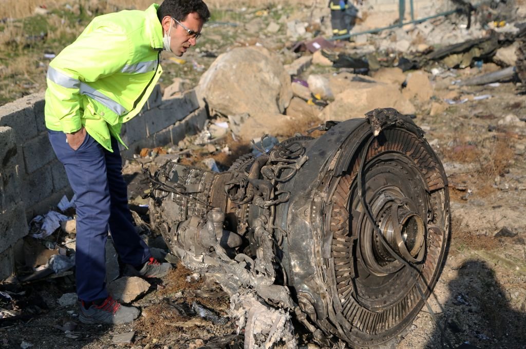 An official inspects debris from the plane on the crash site on January 8
