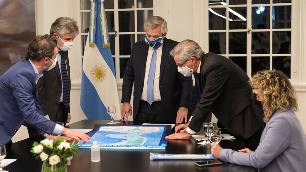 Alberto Fernández (centro) y otros funcionarios, mirando el nuevo mapa de Argentina