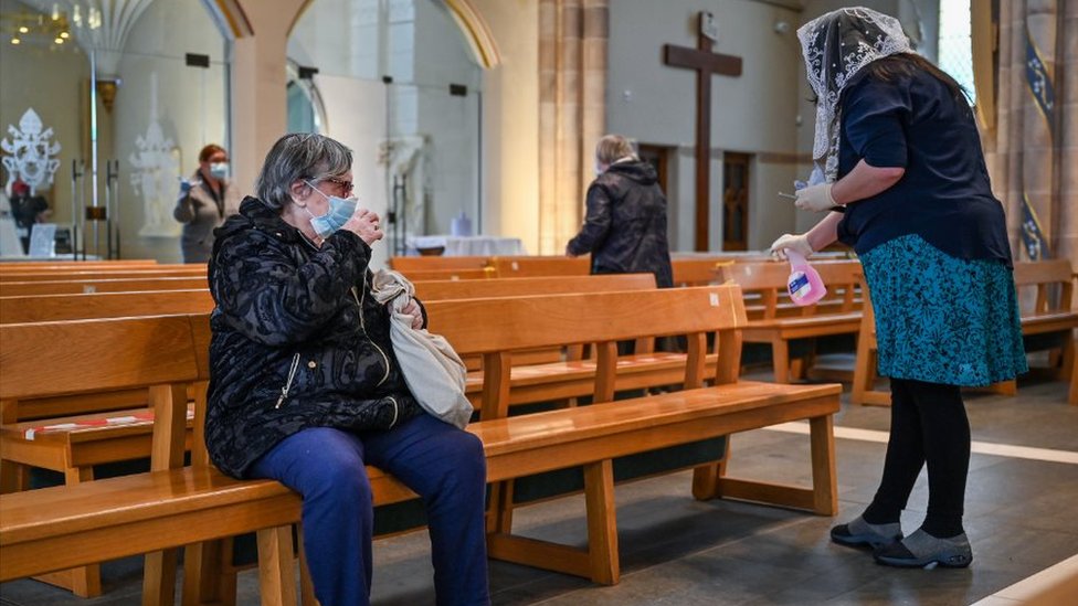 Женщина убирается во время публичной молитвы в соборе Святого Андрея, поскольку места поклонения открываются для частных молитв