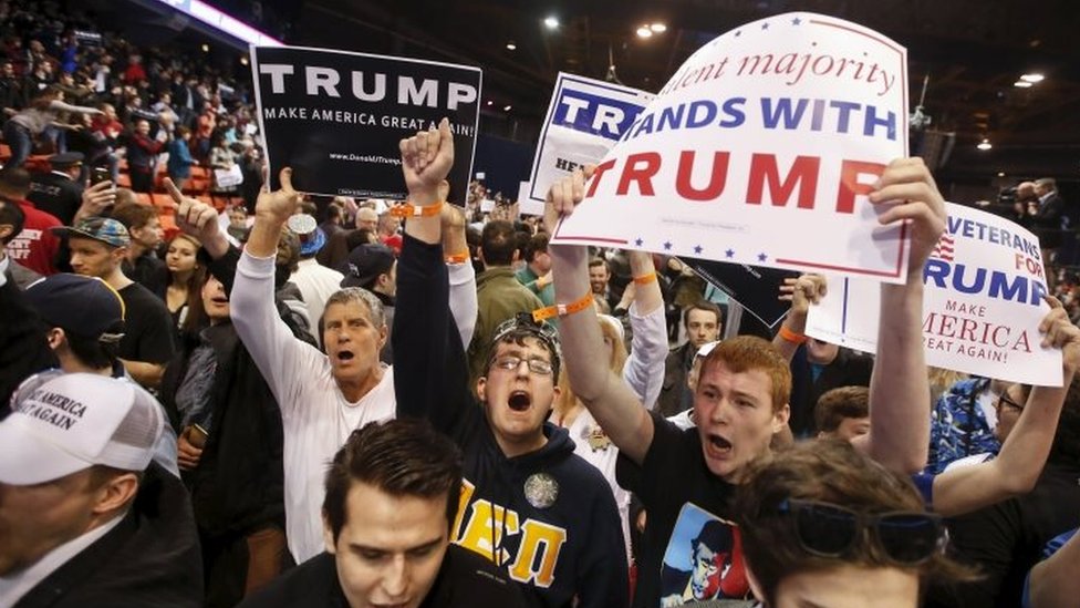 Сторонники Трампа держат плакаты после кандидата в президенты США от республиканцев Дональда Трампа