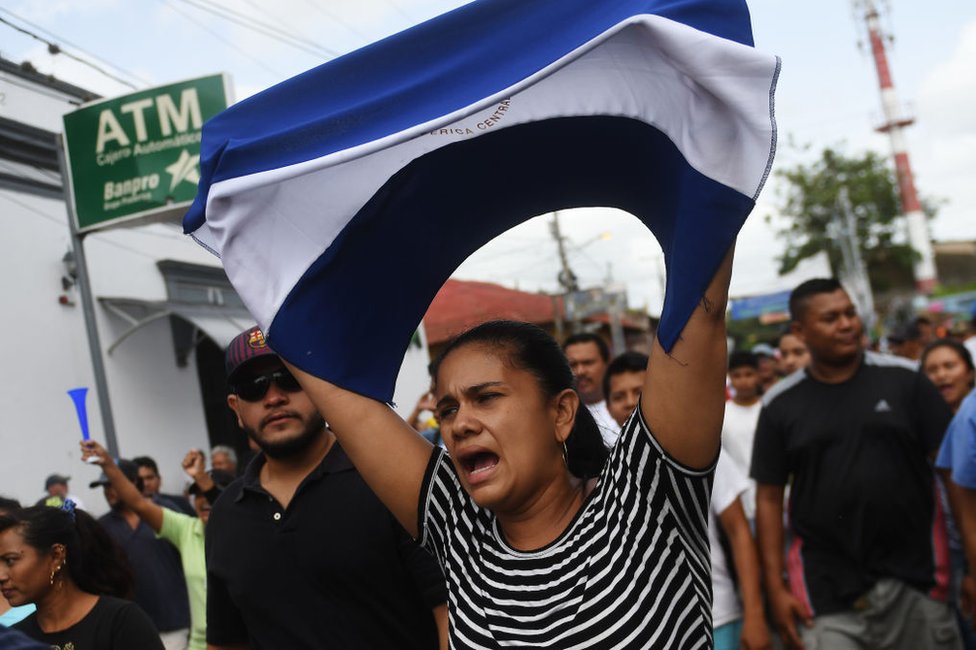 Una mujer sostiene la bandera de Nicaragua durante protesta en ese país.
