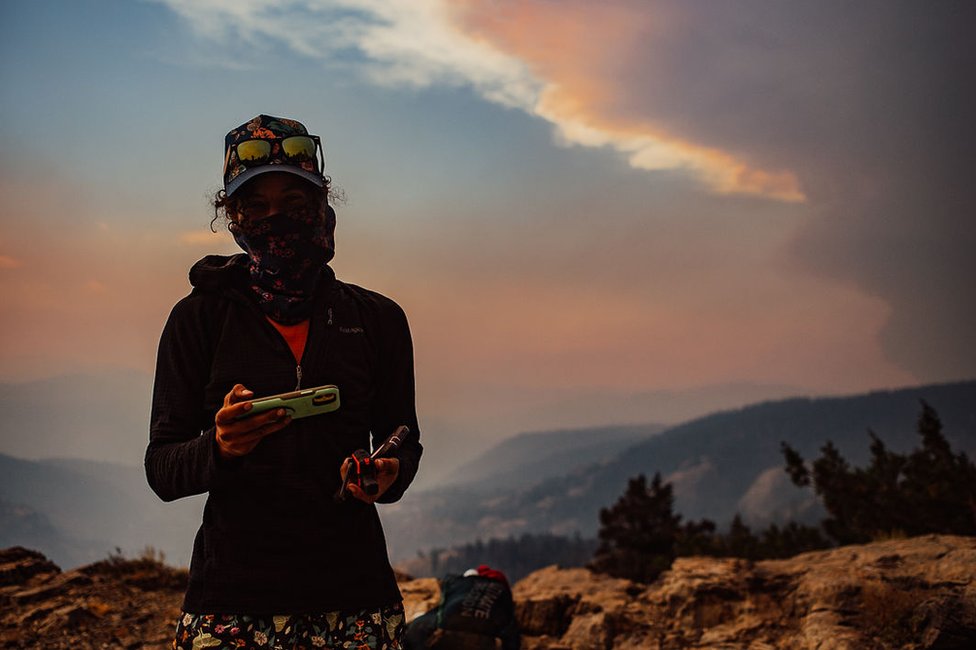 Путешественник в национальном лесу Сьерра на фоне лесного пожара