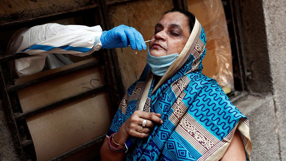 Un trabajador médico recolecta una muestra para detectar covid-19 en Nueva Delhi, India.