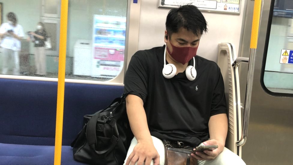 أحد ركاب القطار في طوكيو يرتدي مراوح خاصة تعلق بالرقبة