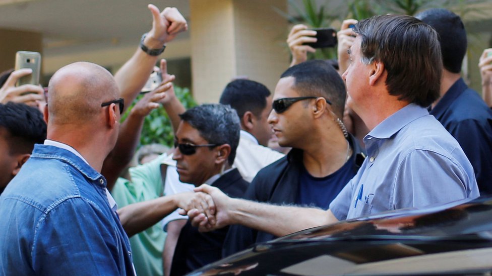 Президент Бразилии Жаир Болсонару приветствует своих сторонников в Бразилиа