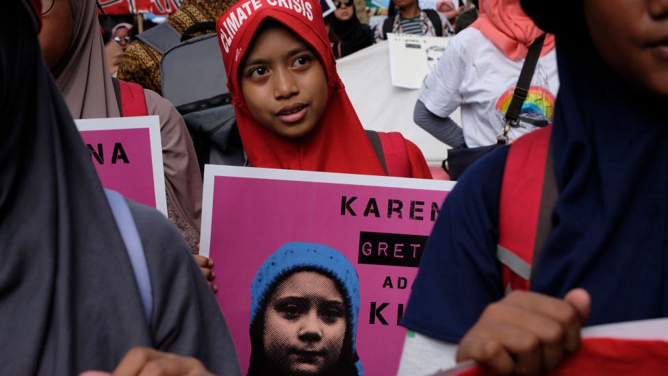 Joven con cartel de Greta Thunberg Joven con cartel de Greta Thunberg
