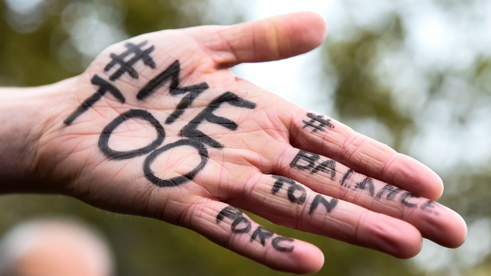 У женщины на ладони написано «# MeToo #» и «#Balancetonporc» на октябрьском мероприятии