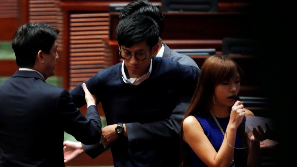 Охранники блокируют законодателя, выступающего за независимость, - избирают Баджо Люна и Яу Вай-чина (справа) от повторной присяги в Законодательном совете в Гонконге, Китай, 2 ноября 2016 года.