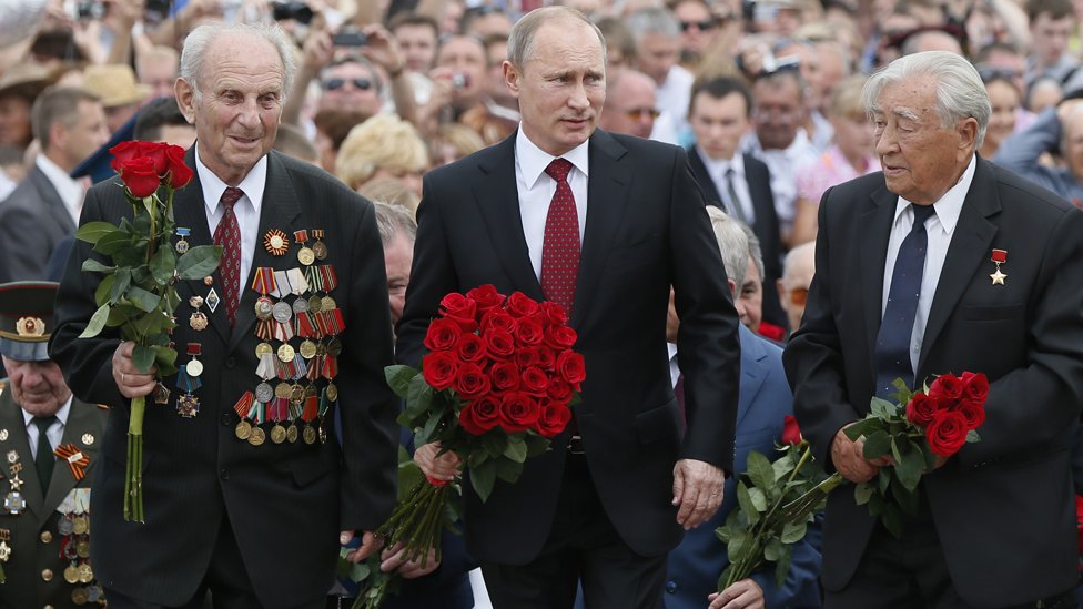 El presidente ruso Vladimir Putin (en el centro) flanqueado por dos veteranos de guerra en un acto de homenaje el 12 de julio de 2013