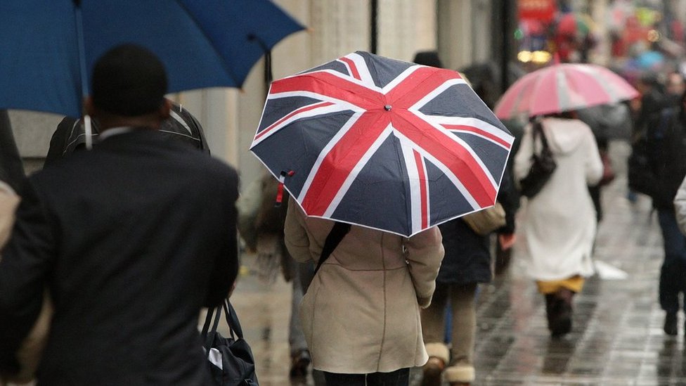 Покупатель держит зонтик, украшенный флагом Юнион Джек