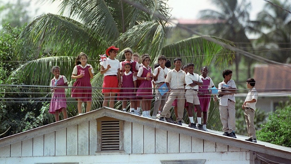 Children gathered on a roof to catch a glimpse of the Queen in Belize in 1994