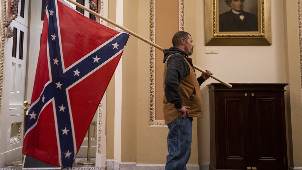 A protester carries the Confederate flag into the US Capitol building