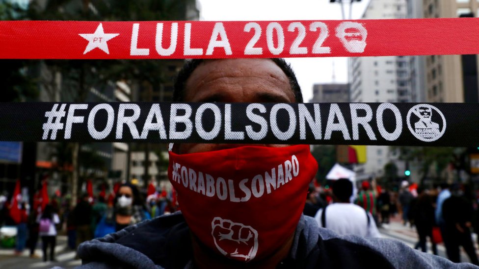 Homem segura faixas onde se lê 'Lula 2022' e 'Fora Bolsonaro'