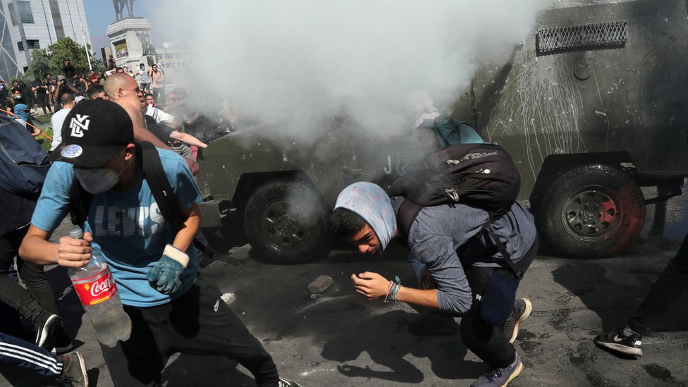 Протестующие укрываются от слезоточивого газа