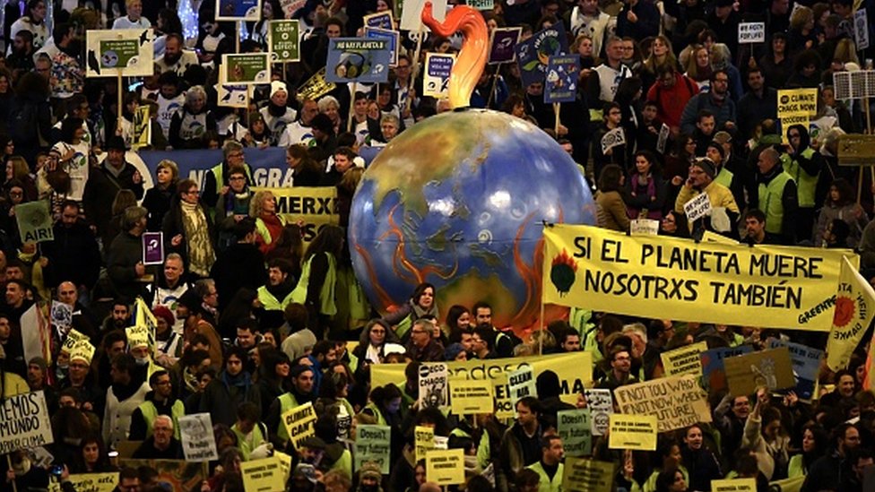 Демонстранты с воздушным шаром в форме Земли принимают участие в массовом климатическом марше