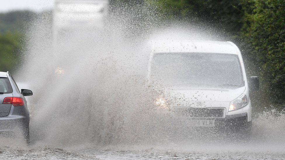 автомобиль и фургон едут по затопленной воде