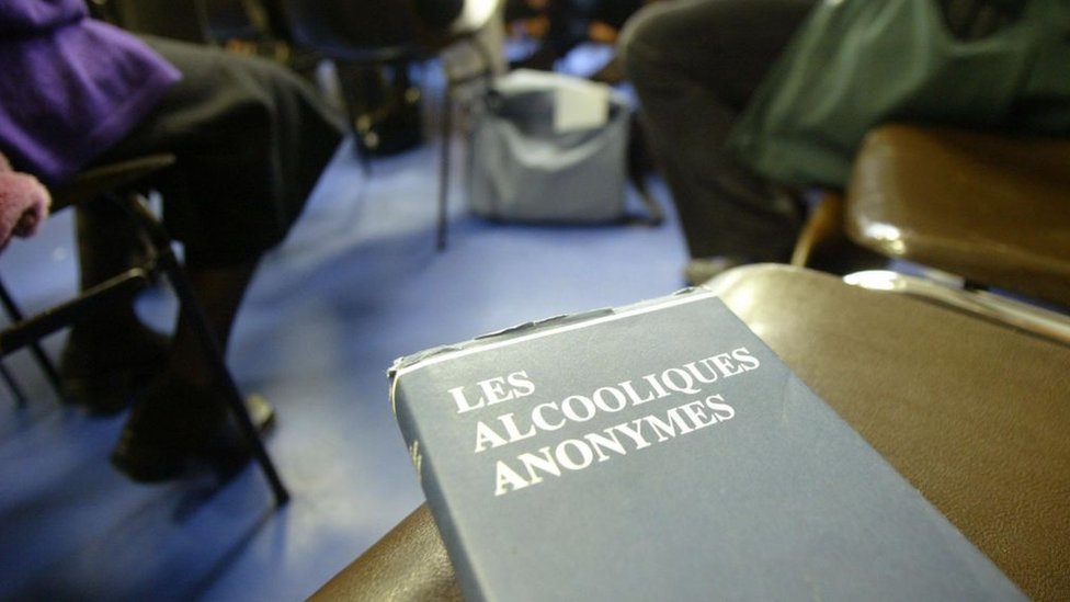 Reunión de Alcohólicos Anónimos y un libro en francés.
