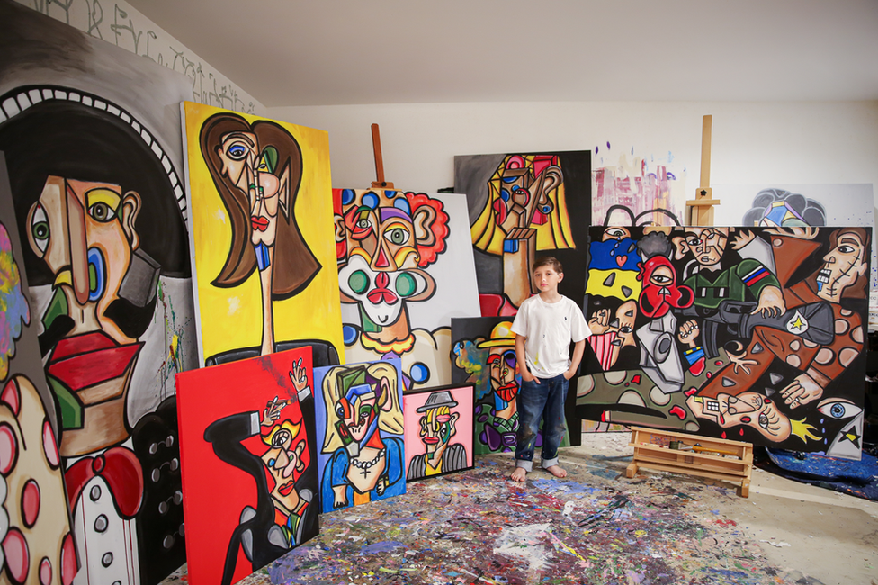 Andrés Valencia en su estudio, rodeado de sus cuadros.