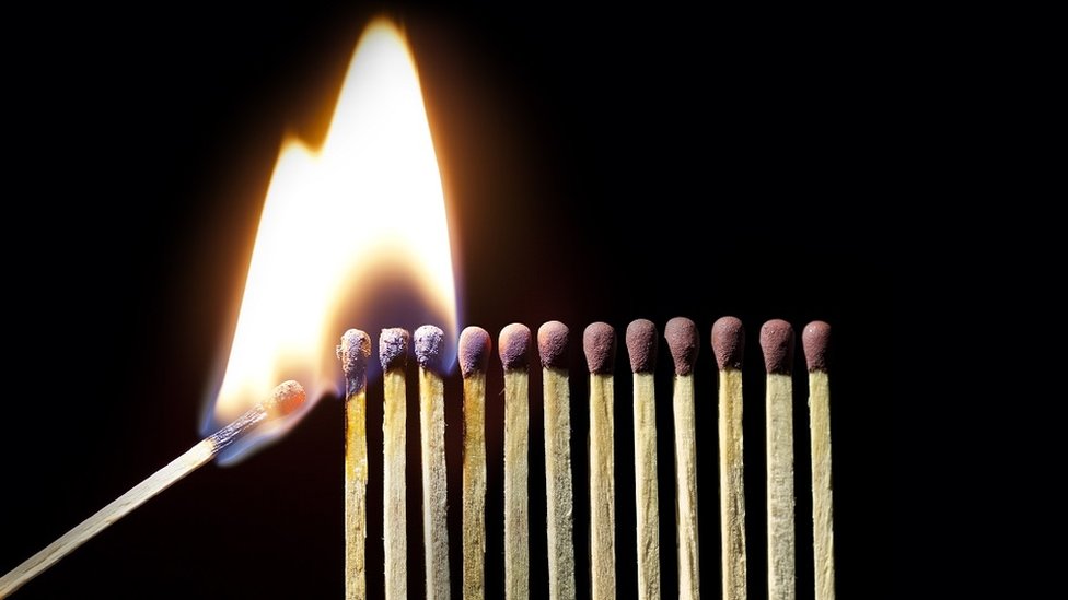 A set of matches being lit, over a black background