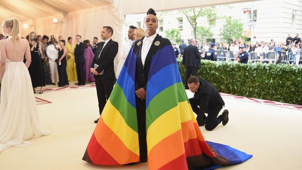 Black writer Lena Waithe wearing the Philadelphia Pride flag as a cape to the Met Gala in 2018