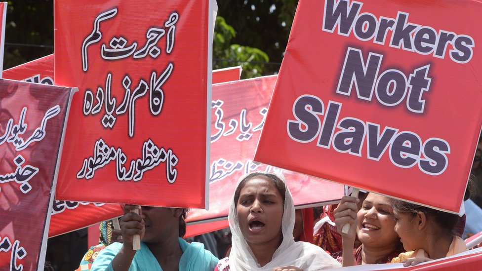 نساء باكستانيات يشاهدن هنا وهن يحملن لافتات ويهتفن بشعارات خلال مسيرة في مدينة لاهور