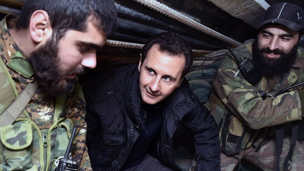 В эту среду, 31 декабря 2014 г., фото из архива, опубликованное сирийским официальным информационным агентством SANA, президент Сирии Башар Асад (в центре) беседует с сирийскими войсками