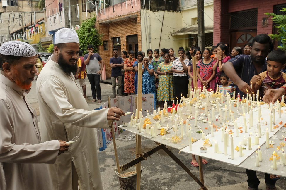 Sri Lankan Muslims light candles and offer prayers outside the St. Anthony