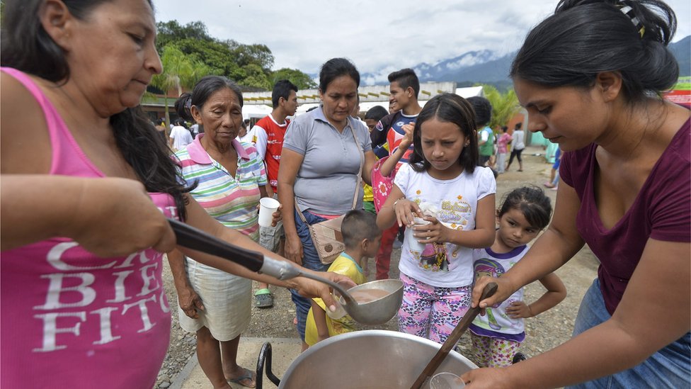 En la localidad se han instalado centros de refugio temporales donde las familias pueden dormir y comer. Dos mujeres sirven tazones de chocolate a los niños.