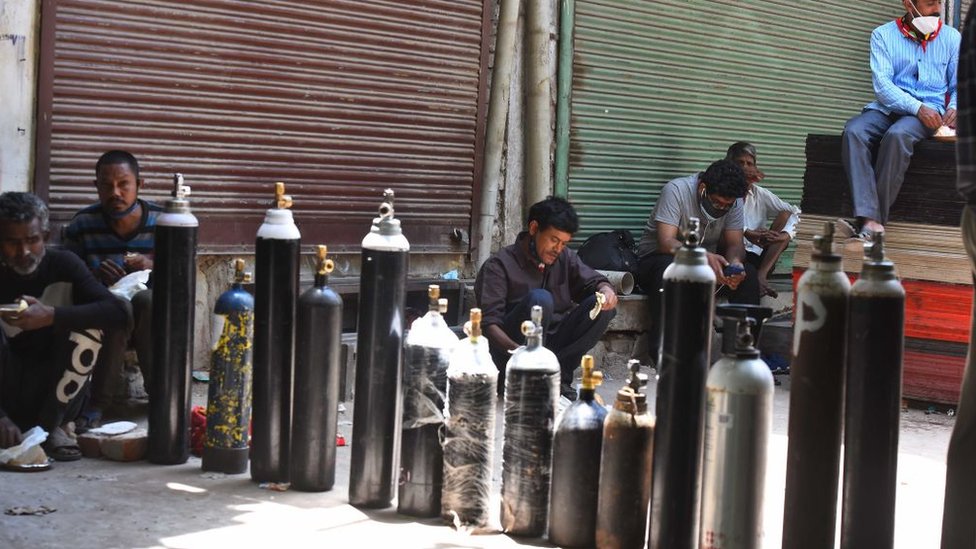 أشخاص ينتظرون الحصول على أسطوانات أكسجين وعبوات جديدة في مركز تعبئة في نيودلهي، الهند