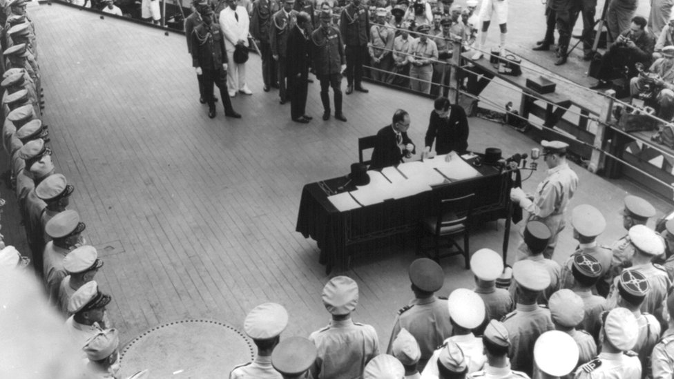 日本外相重光葵（桌前就坐者）在停靠東京灣的美國海軍密蘇里號甲板上簽署投降文書（2/9/1945）